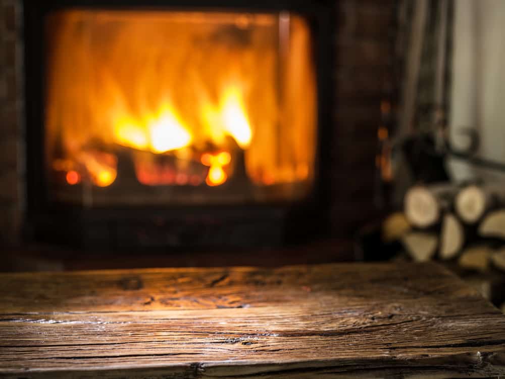 Old,Wooden,Table,And,Fireplace,With,Warm,Fire,On,The