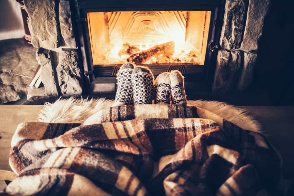 Feet,In,Woollen,Socks,By,The,Christmas,Fireplace.,Couple,Sitting