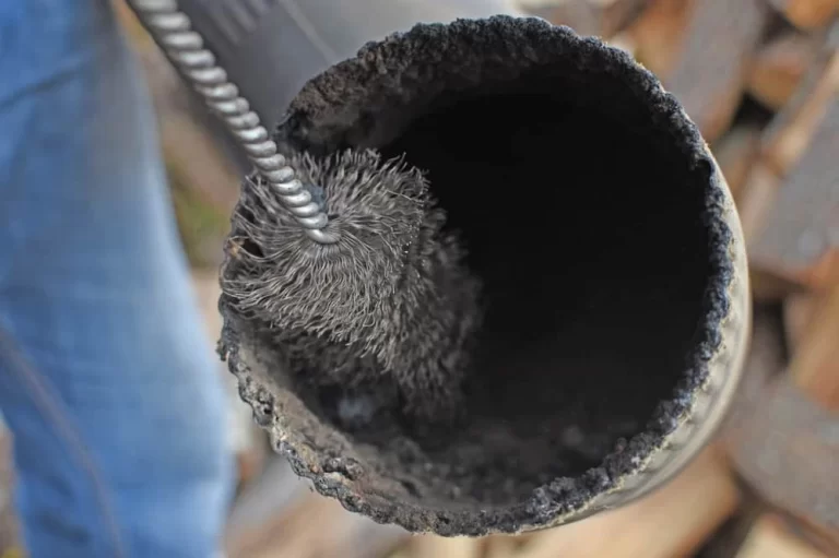 Man Cleaning Chimney Pipe Outside. Cleaning A Wood Burning Stove.