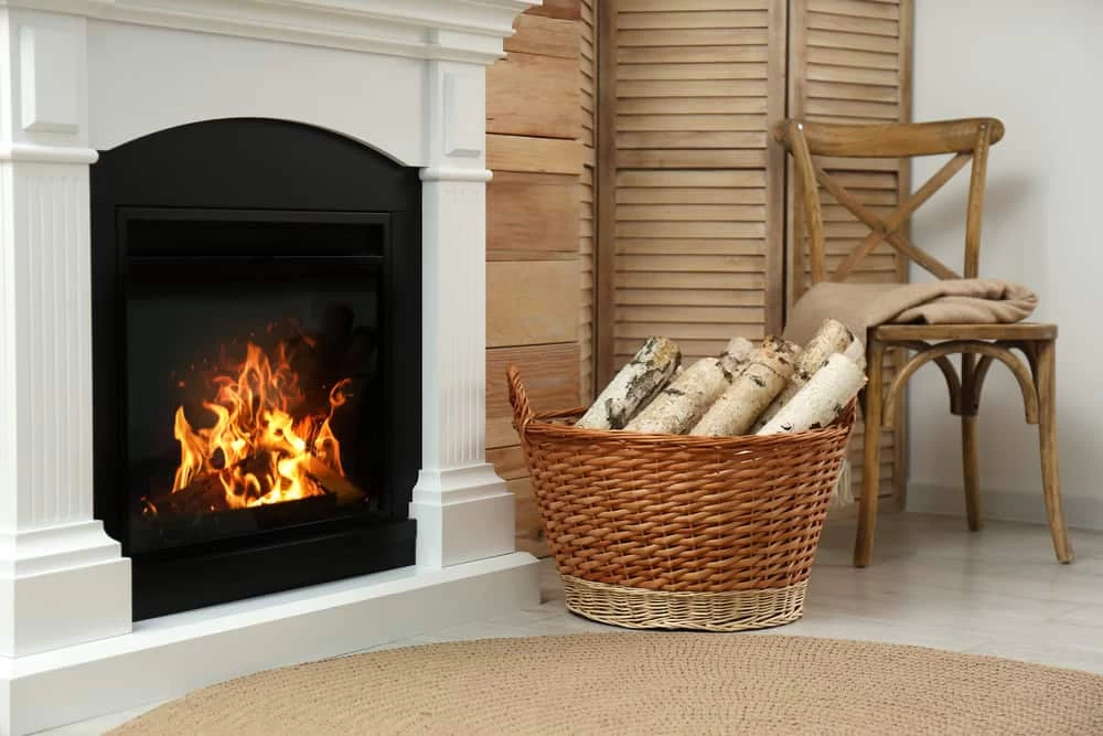 Firewood in Wicker Basket Near Fireplace Indoors