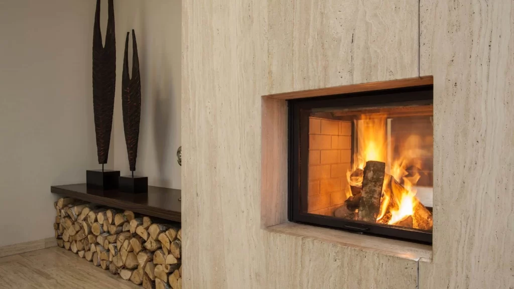 A fireplace with logs and wood stacked against the wall.