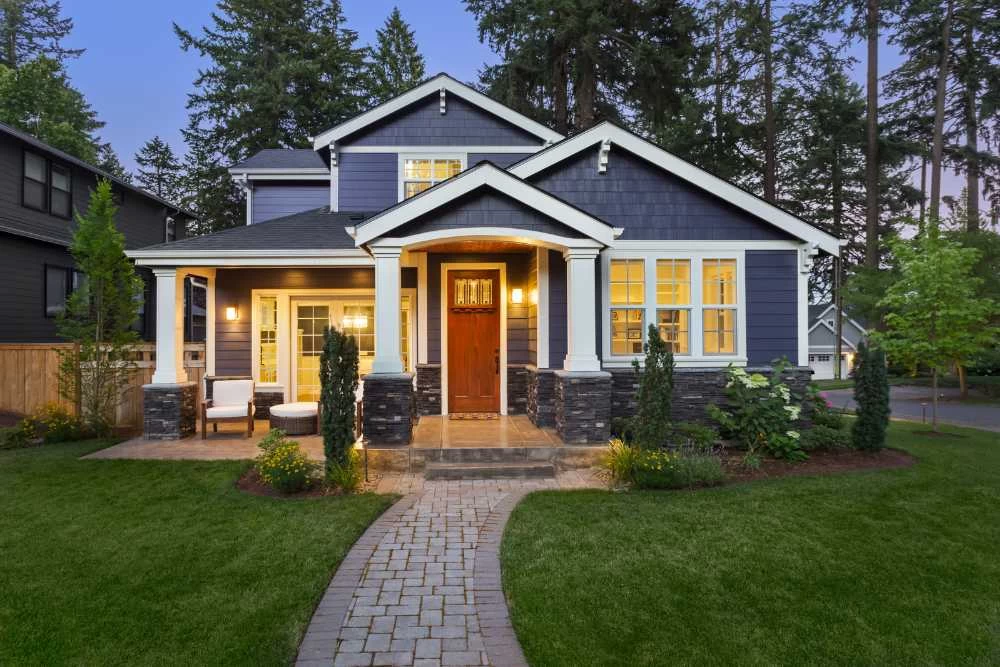 A nice blue house with a walkway leading to the front door.